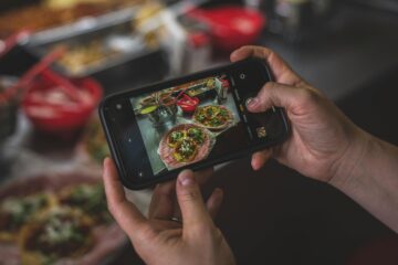 Influencer fotografiando platos en restaurante que aplica marketing gastronómico 2026